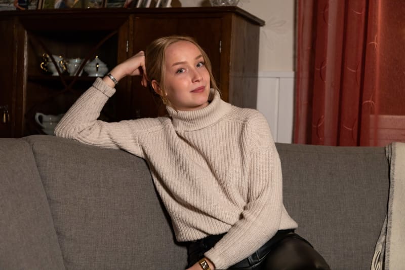 Saara Lassila is sitting on the couch at home.