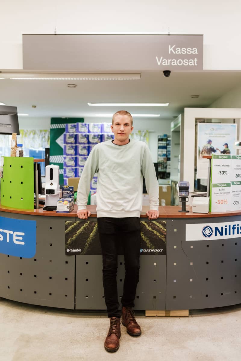 Jani Lyytinen looks at the camera at the checkout of her store.