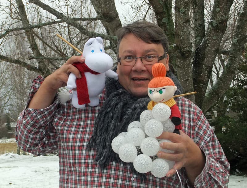 Juha Laukkanen holding Moomin dolls.