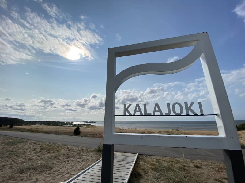 Дерев’яний знак, який говорить Калайкі. На тлі моря.
