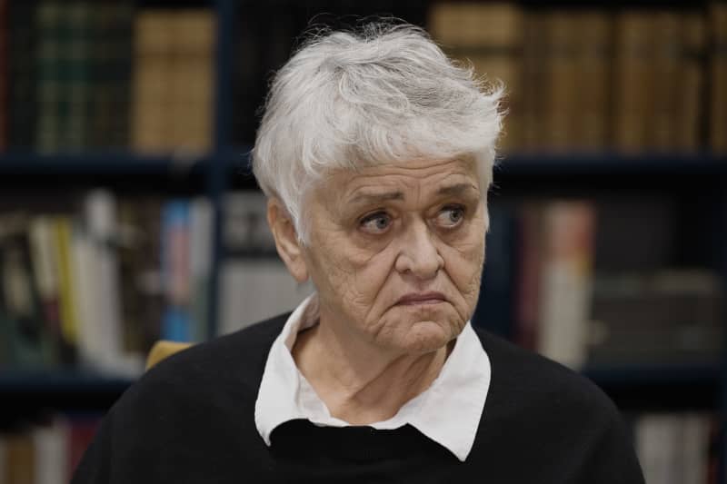 Піркко Саісіо замисленим голосом дивиться вбік.  позаду видно книжкову полицю.  напів крупним планом.