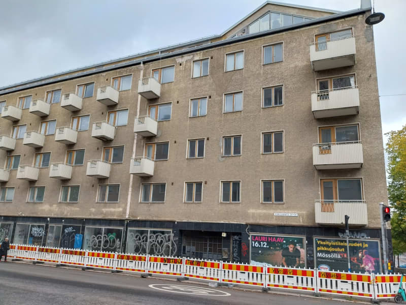 Блок квартир з вулицею та парканом.