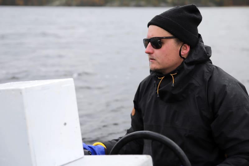 Metsähallitus special expert Eetu Karhunen steers the boat in Saimaa.