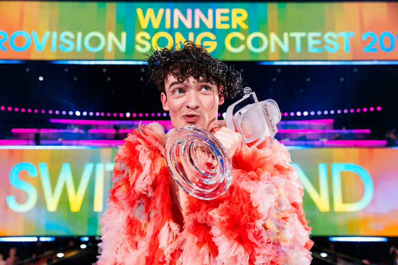Nemo poses on stage with a glass microphone trophy.