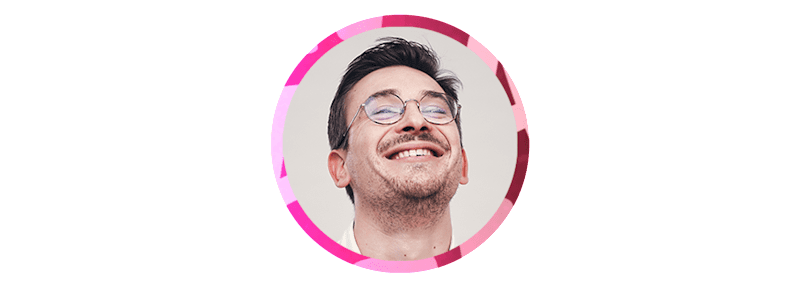 The bespectacled man smiles.
