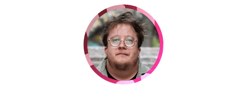 A man with glasses looks straight ahead.