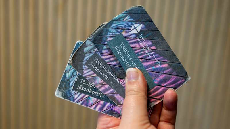 Three Töölö parish membership cards in hand.
