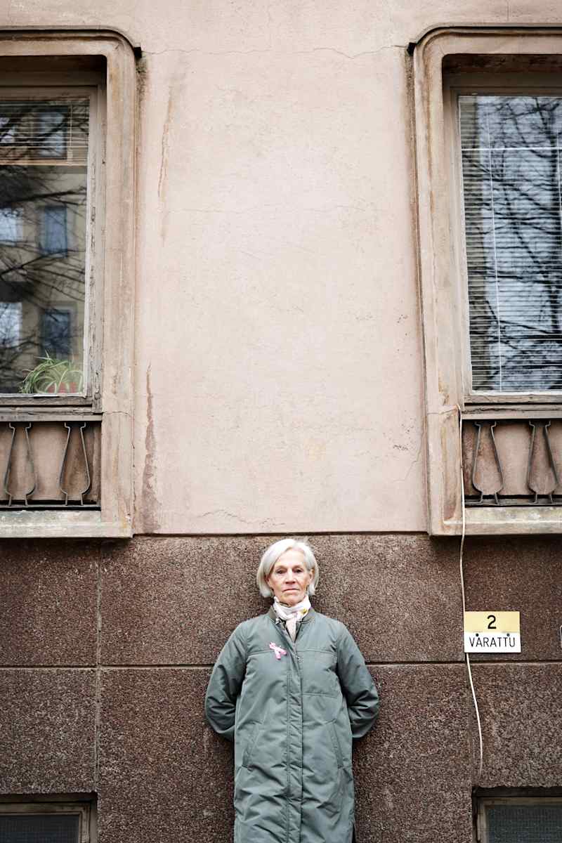 The person leans on the wall of the building.