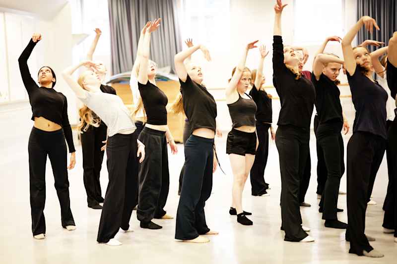 The group dancers are practicing in the dance hall.