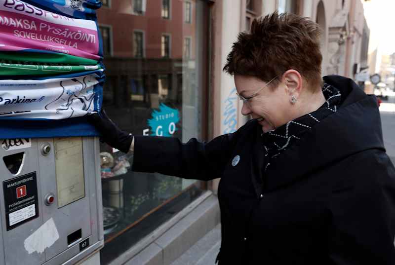 Eeva Jauro, Managing Director of Lahden Parking Oy, raises the hood over the dismissed parking machine.