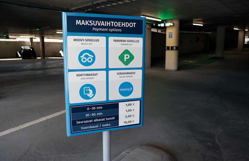 A sign on payment methods at the entrance to the parking lot.