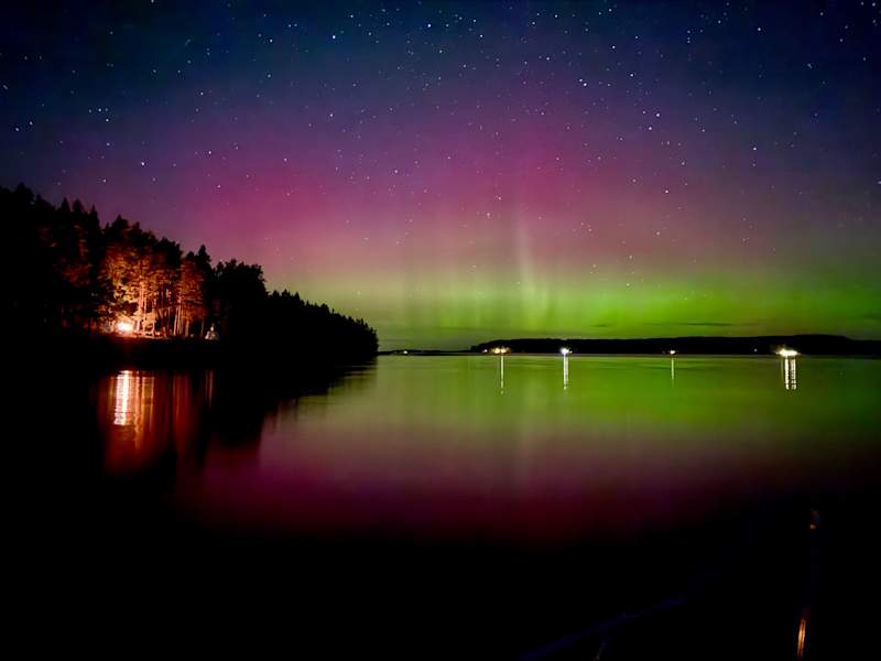 Colorful northern lights in the lake landscape.