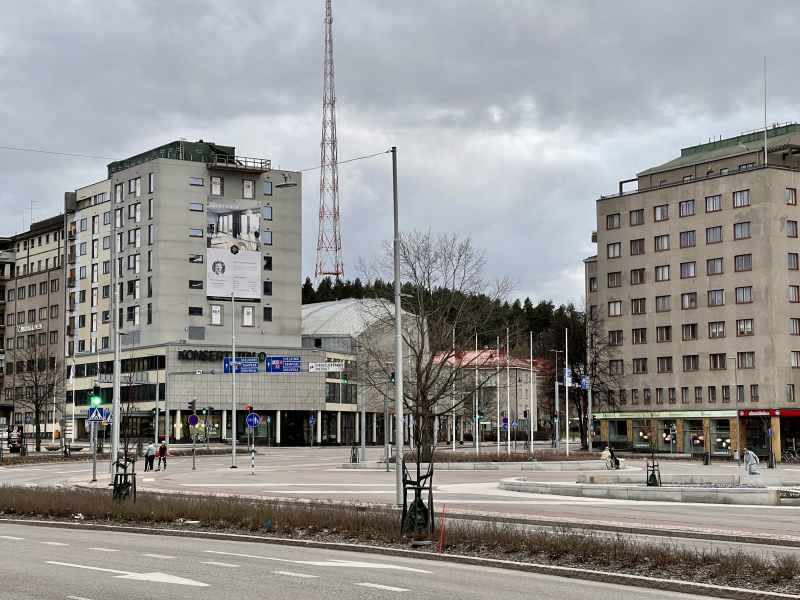 Велика вулиця, що веде до центру міста. Квартирні будівлі у фоновому режимі. Житловий рекламний будинок в одному незавершеному багатоквартирному будинку.