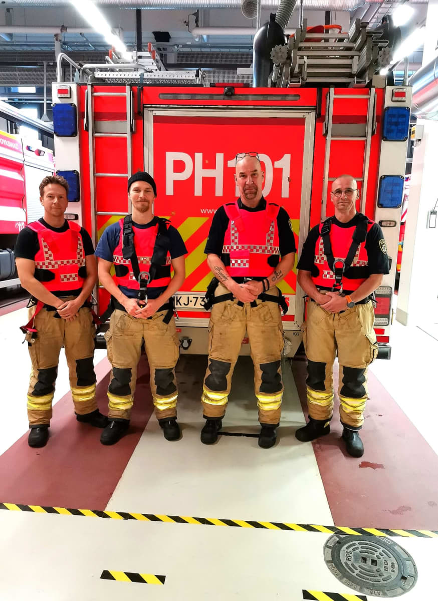 Päijät-Hämeen pelastuslaitoksen palomiehiä suojaliiveissä paloauton edessä.