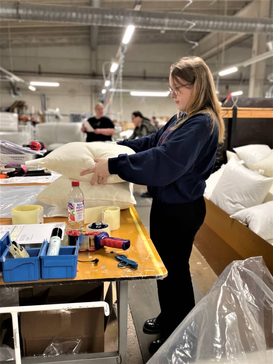 Pakkaaja Aliisa Juvonen pakkaa tyynyjä Lennolin tehtaalla Jalasjärvellä.