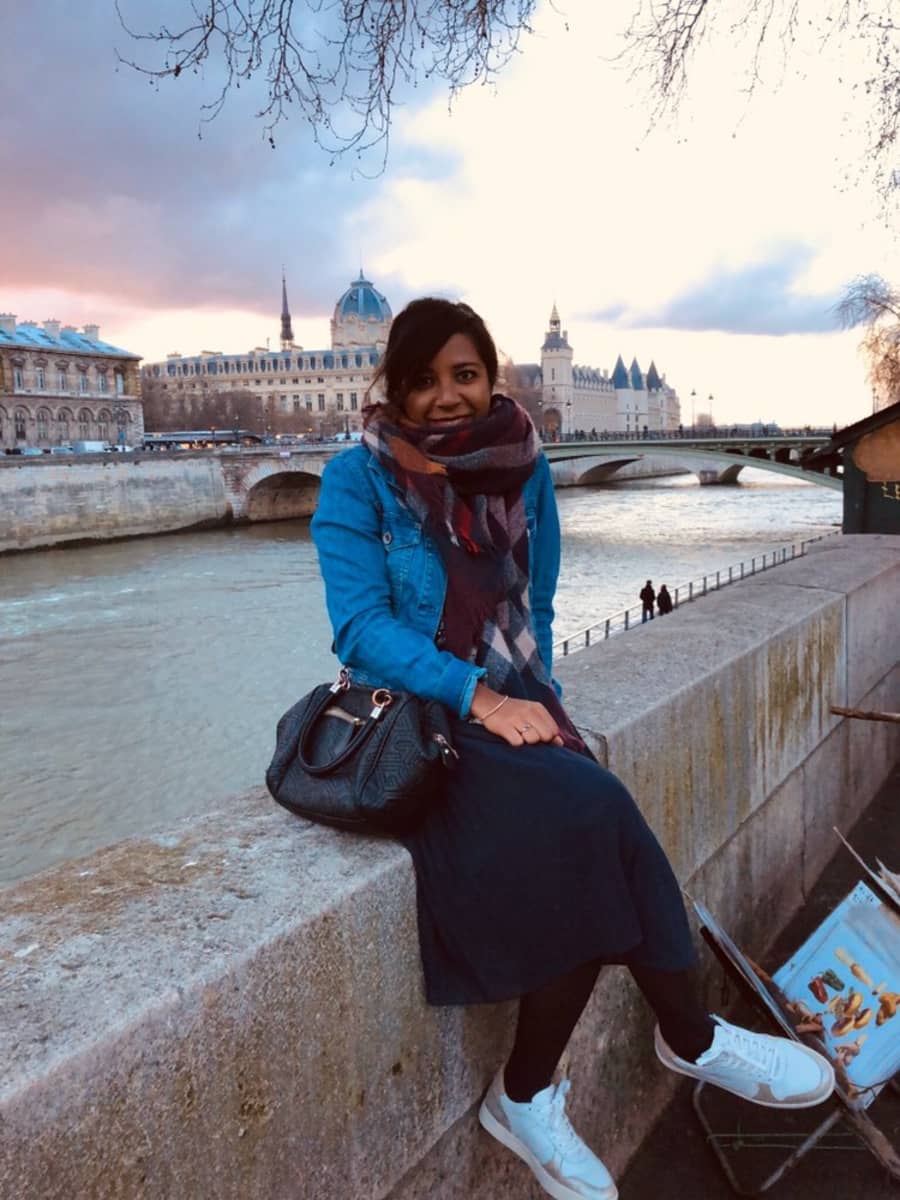 Priscilla Ravelojaona istuu Pariisissa Seine-joen edustalla