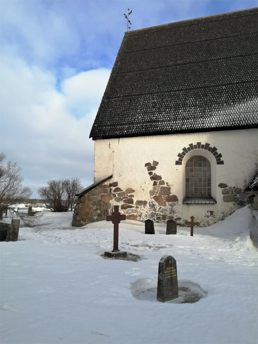Isonkyrön vanha kirkko talvimaisemassa, etualalla eteläpäädyn kulma.