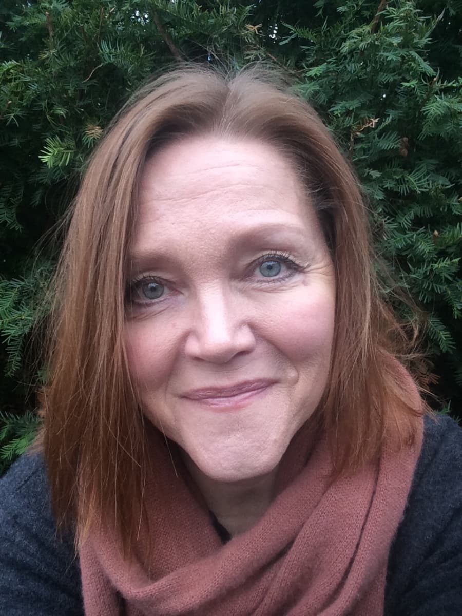 Julia Virkkunen katsoo kameraan ja hymyilee. 