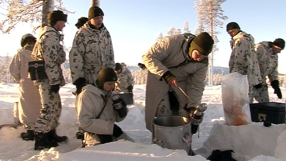 Varusmiehet ruokailevat talvisessa metsässä.