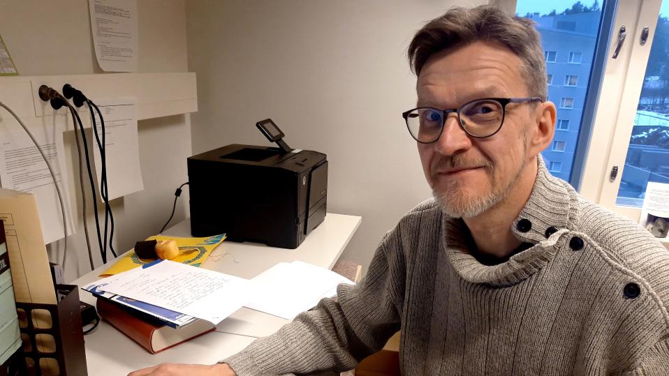 Itä-Suomen yliopiston keuhkosairauksien professori Heikki Koskela istuu työpöytänsä ääressä.
