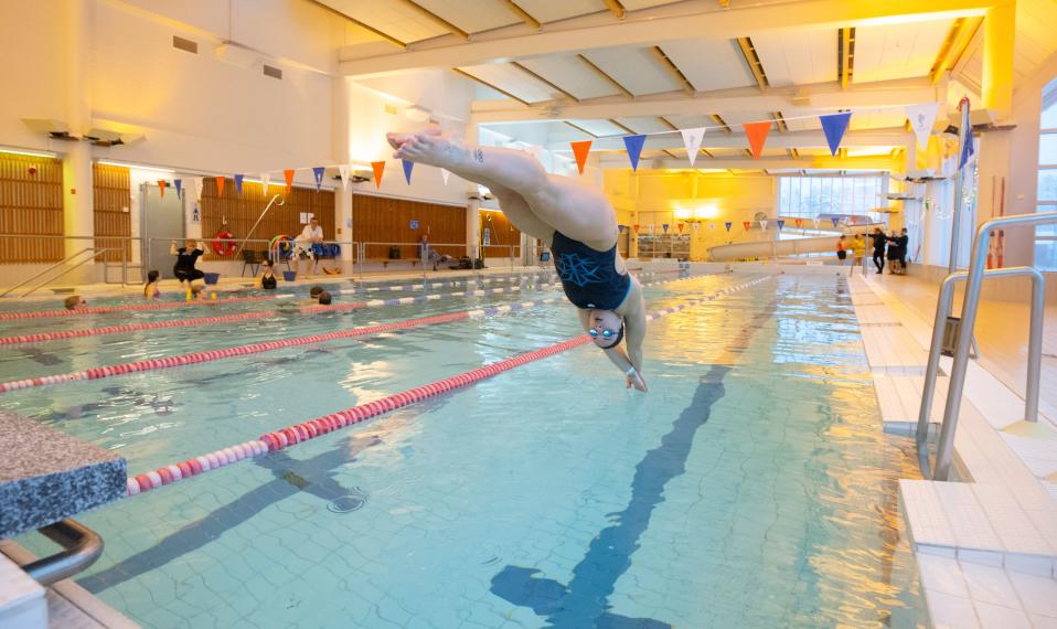 Jenna Laukkanen ponnistaa uima-altaaseen.