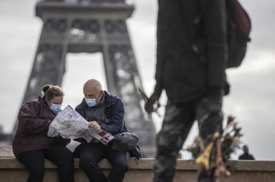 Maskeihin pukeutuneet turistit tutkivat karttaa Eiffel-tornin lähellä Pariisissa marraskuun alussa.