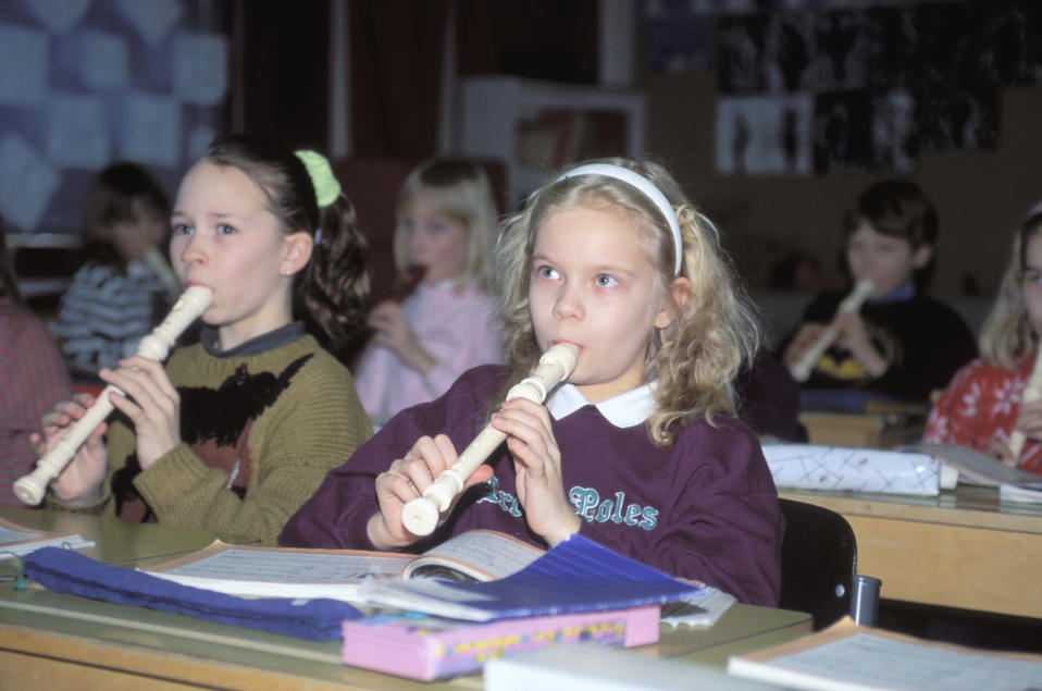 Lapset soittavat nokkahuilua musiikin tunnilla luokkahuoneessa vuonna 1990.