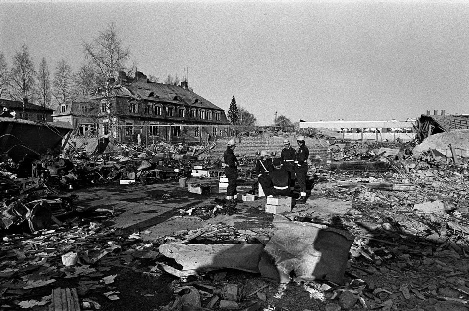 Pelastusmiehet istuvat patruunalaatikoilla Lapuan patruunatehtaan räjähdyspaikalla.