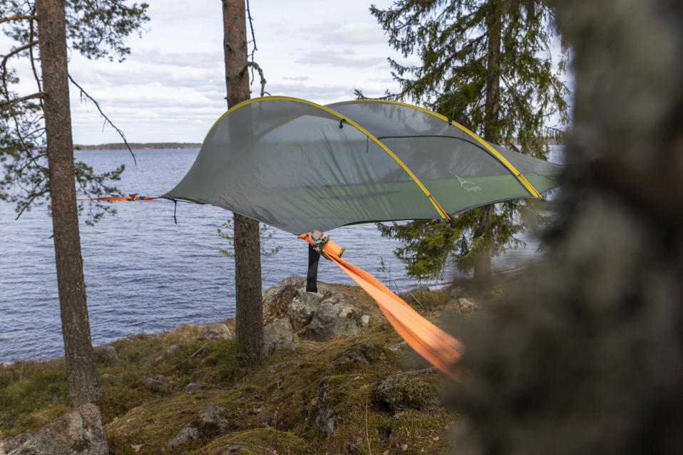 Tentsilen teltta pingotettuna ilmaan puiden väliin Kyyjärven leirintäalueen rantamaisemassa
