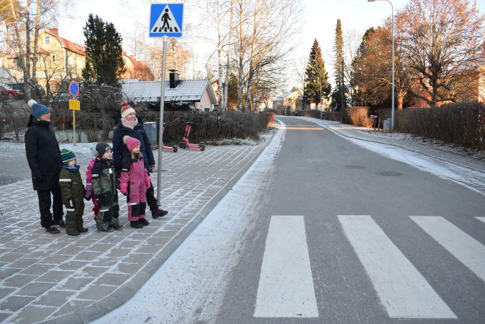 Esiopettaja Anna Alanen ja varhaiskasvatuksen opettaja Janna Liikkanen päivkotilasten kanssa menossa suojatielle.