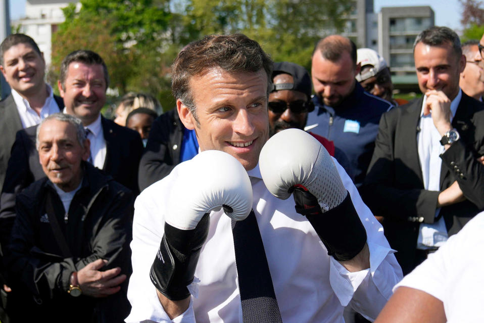 Emmanuel Macron poseeraa nyrkkeilyhanskat kädessään.