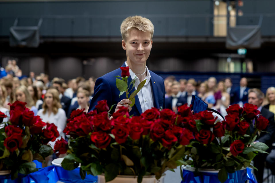 Joakim Oldorff saa ruusun ylioppilasjuhlassa.