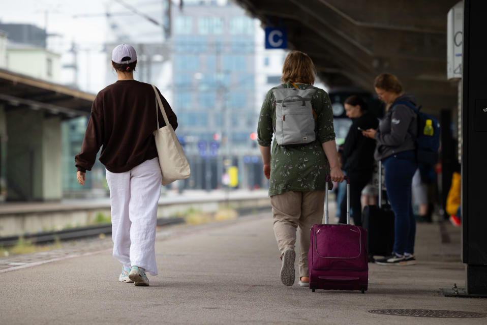 Matkustajia laukkuineen Tampereen rautatieasemalla.