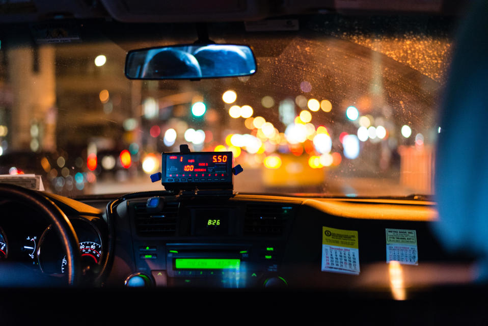 Förar- och passagerarsätet i en taxibil fotograferat från baksätet.