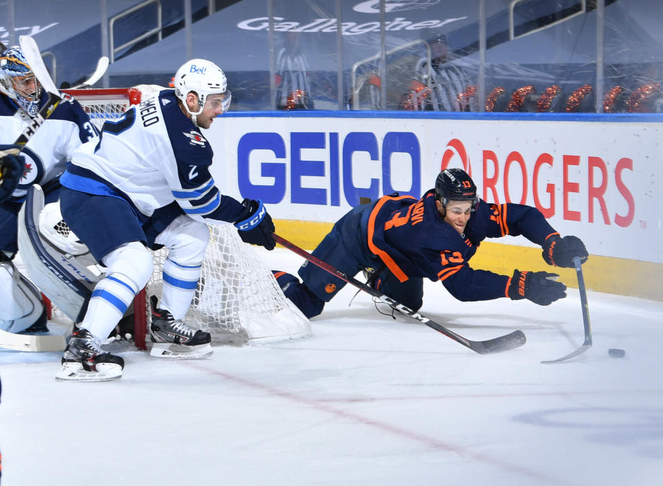 Jesse Puljujärvi heittäytyy kiekon perään Winnipegin maalin takana.