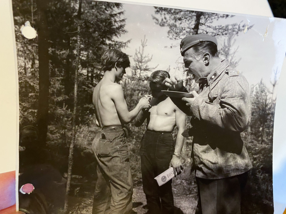 Näyttelijä Tauno Palo ruokailee kuvaustauolla. Taustalla kamera-assistentit Antero Ruuhonen ja Veikko Mård (keskellä) tupakalla. 