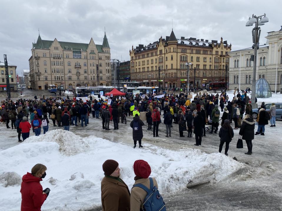 Protesters at Tampere Central Market.  Picture from far away, in the background you can see Hämeenkatu.  There is a lot of snow in the market. 