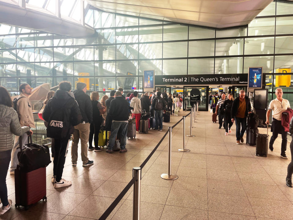Ihmiset jonottavat Heathrow'n lentokentällä pitkissä jonoissa.