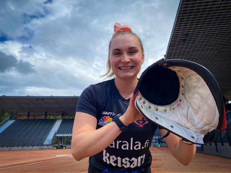 Siri Eskola poseeraa pesäpalloräpylän kanssa Kaupin pesäpallostadionilla.