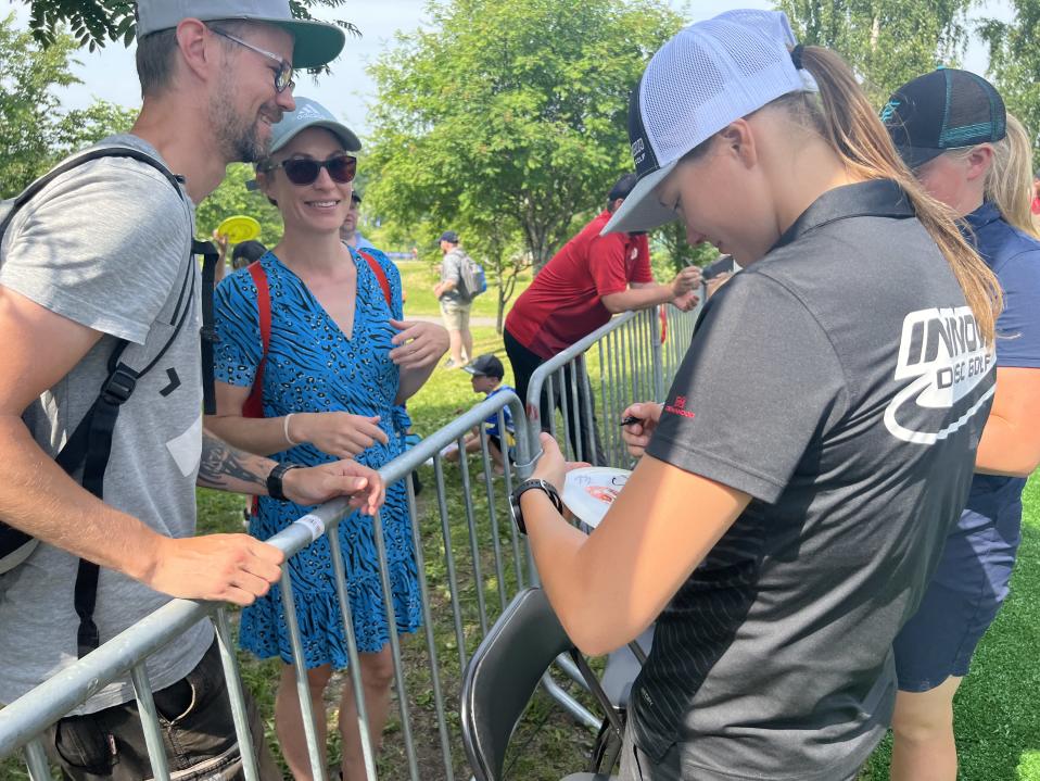 Paige Pierce signs fans discs after finishing her round on Friday. She has previously won the event in 2013 and 2019.