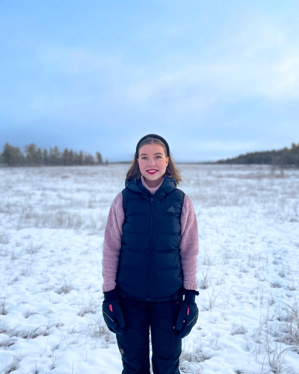 Riikka Karppinen seisoo tumput kädessä lumisella, aavalla Viiankiaavan suolla.