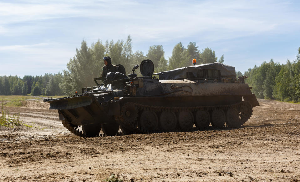 Puolustusvoimien aseistamaton MT-LB tela-alustainen panssaroitu ajoneuvo ajamassa hiekkatiellä.