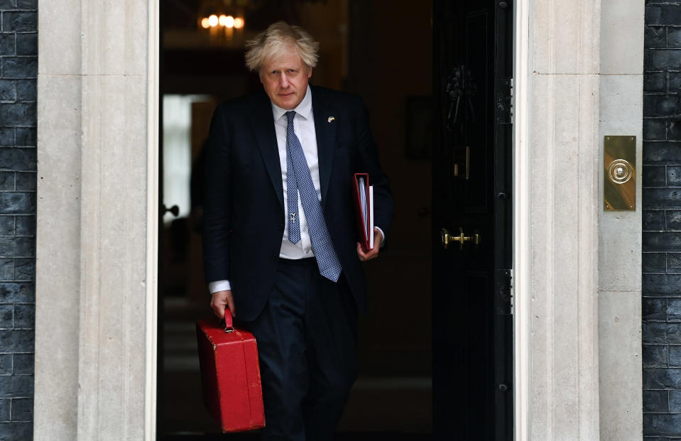 Boris Johnson poistuu pääministerin virka-asunnosta kädessään punainen salkku.