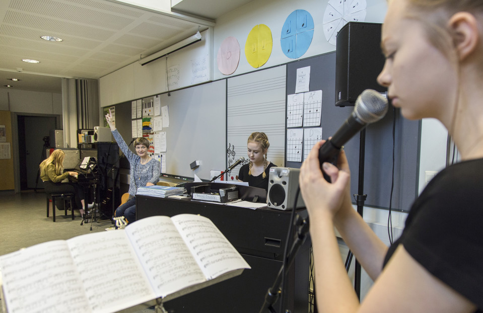 Oppilas laulaa mikrofoniin.