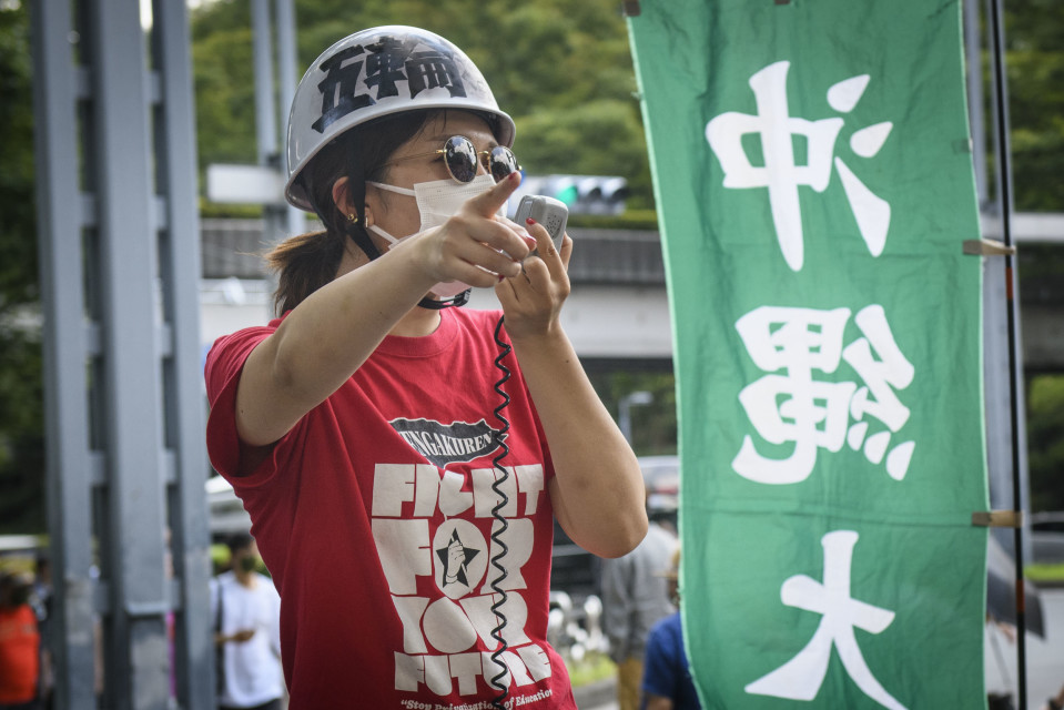 Opiskelijat osoittivat mieltään Tokion olympialaisia vastaan kaupungintalon edessä.