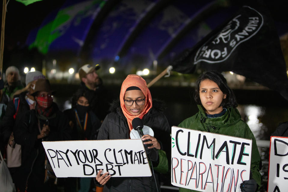 Greenpeacen ilmastoaktivistit osoittivat Glasgow'ssa mieltään maanantaina. Farzana Faruk puhuu, Maria Reyes seisoo oikealla.