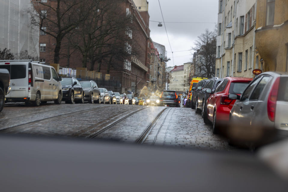 Kadunvarret täynnä pysäköityjä henkilöautoja. 