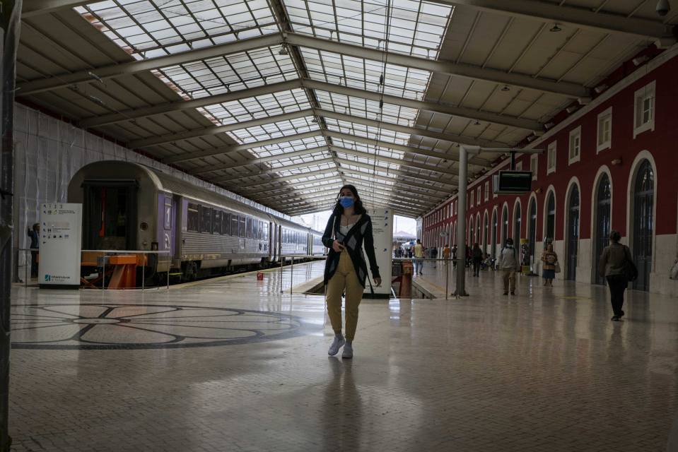 Henkilö maski päällä kävelee juna-asemalla. Santa Apolonia train station. Lisbon, May 23, 2022.