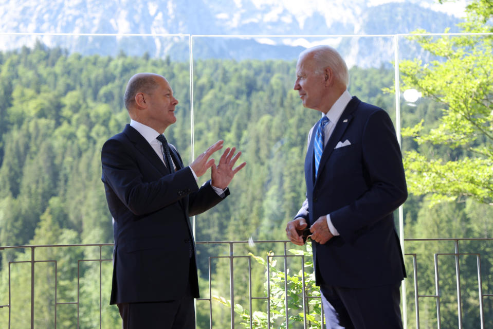 Olaf Scholz ja Joe Biden keskustelevat vuoristoisen maiseman edessä.