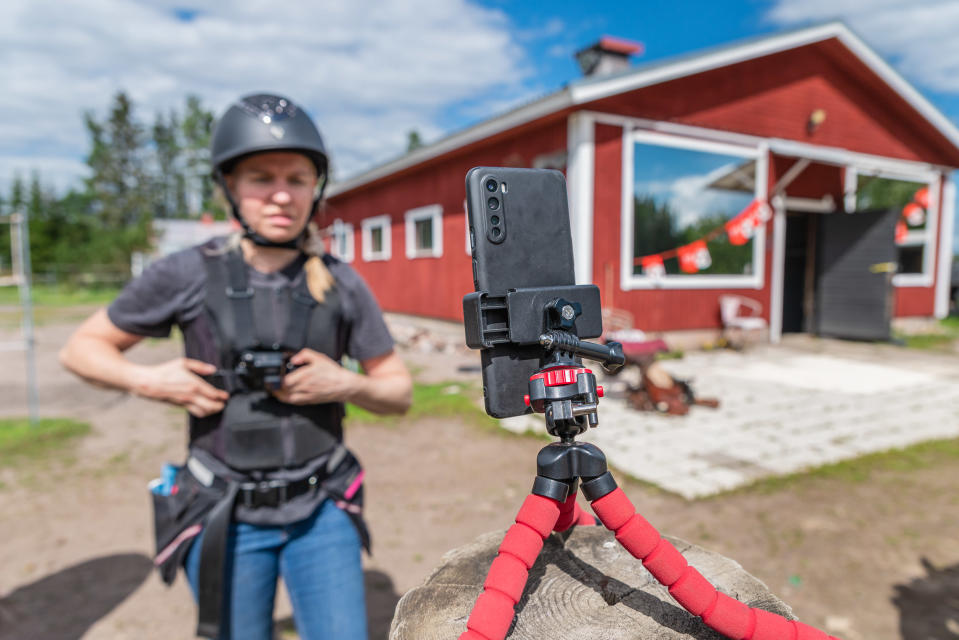 Kaisa kuvaa itseään kännykällä ja riisuu Go-pron valjaita.